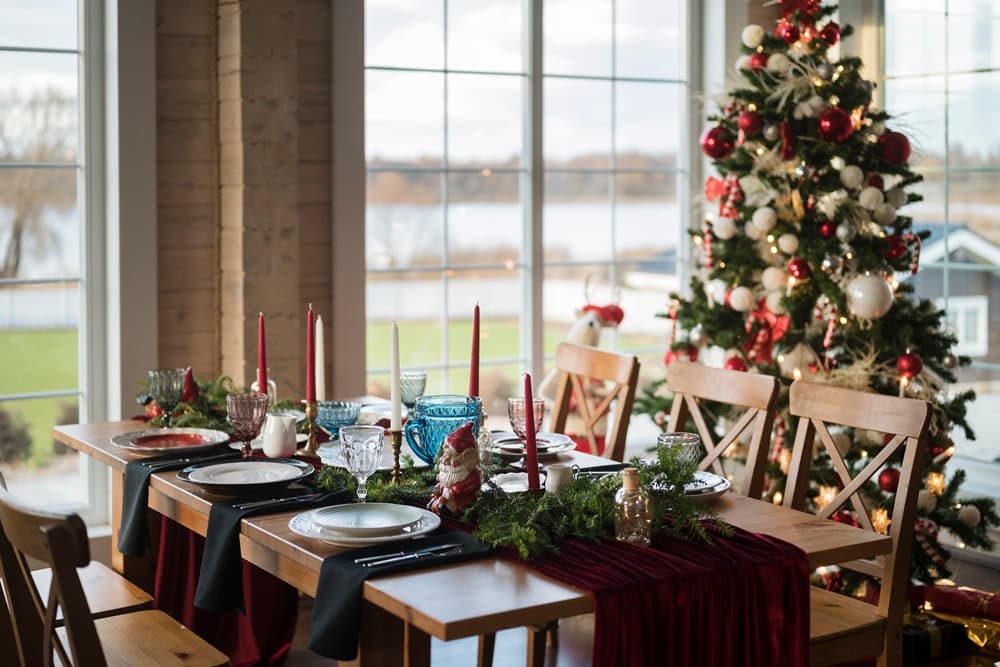 Festive Christmas table decorated with a green garland runner and candles.