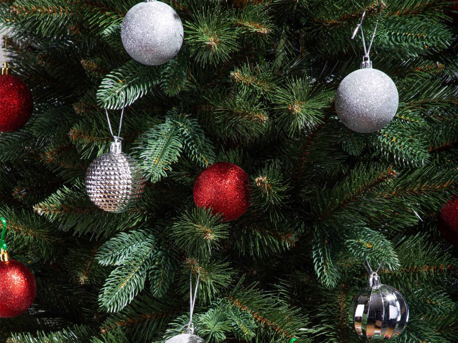 FairyTrees FT33 artificial fir tree in a beautiful dark green color decorated with classic baubles