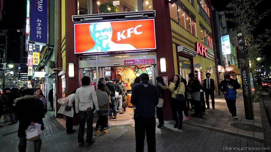 People stand in a long line outside a KFC restaurant on a street in Tokyo during Christmas in 2010.