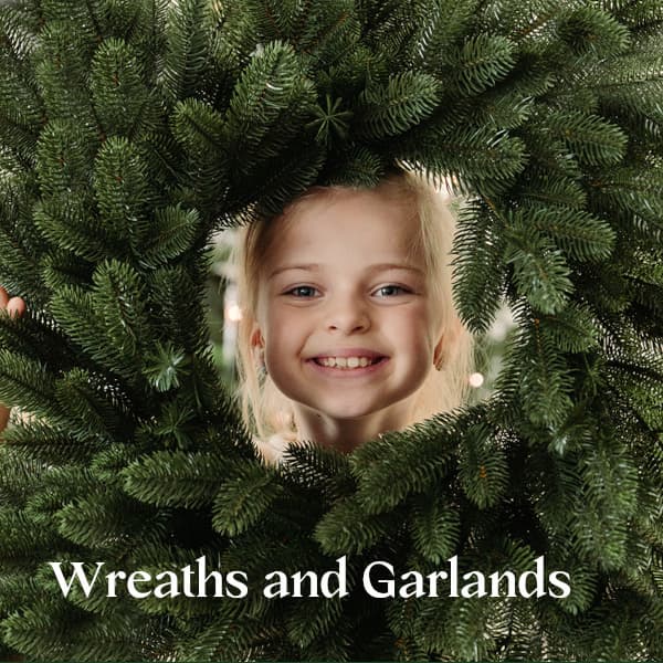 A girl looks through a FairyTrees Christmas wreath